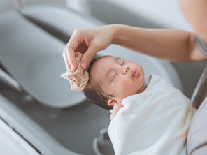 Asian mom washing newborn child in their baby bath. Asian mom washing newborn child in their baby bath.