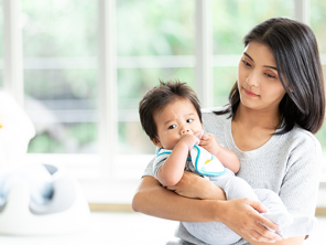 Young Asian mom carrying her baby and thinking about how to increase breast milk supply. Young Asian mom carrying her baby and thinking about how to increase breast milk supply.