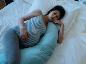 A pregnant Asian woman lying in bed awake due to insomnia during pregnancy A pregnant Asian woman lying in bed awake due to insomnia during pregnancy