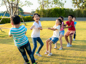 Asian children of mixed genders play tug-of-war outdoors Asian children of mixed genders play tug-of-war outdoors