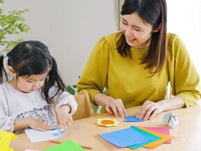 Asian mom and child crafting with construction paper Asian mom and child crafting with construction paper