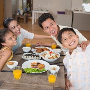Asian boy takes a selfie with his family before they eat a meal that includes minerals in food.