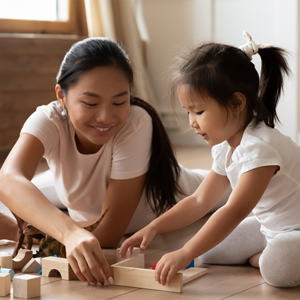 Asian mom and daughter lining up wooden blocks