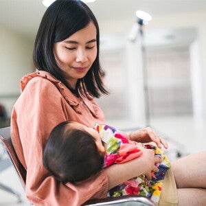 Asian mom consoling crying baby