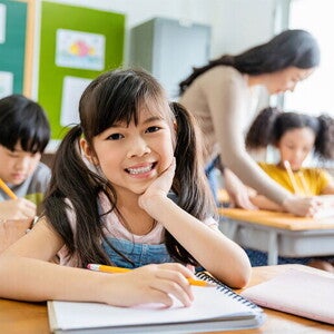 Your Asia child with notebook in classroom